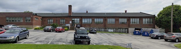 Brick building with cars in parking lot.