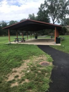 Park pavilion with picnic tables and path.