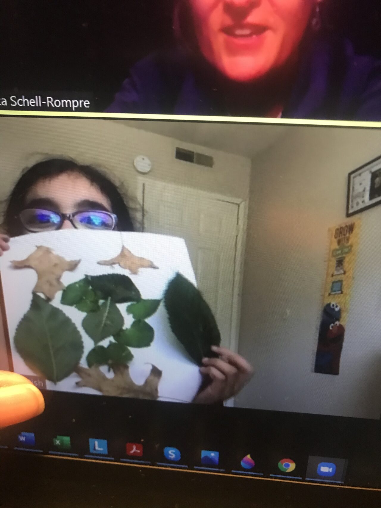 A woman holding up a picture of leaves.