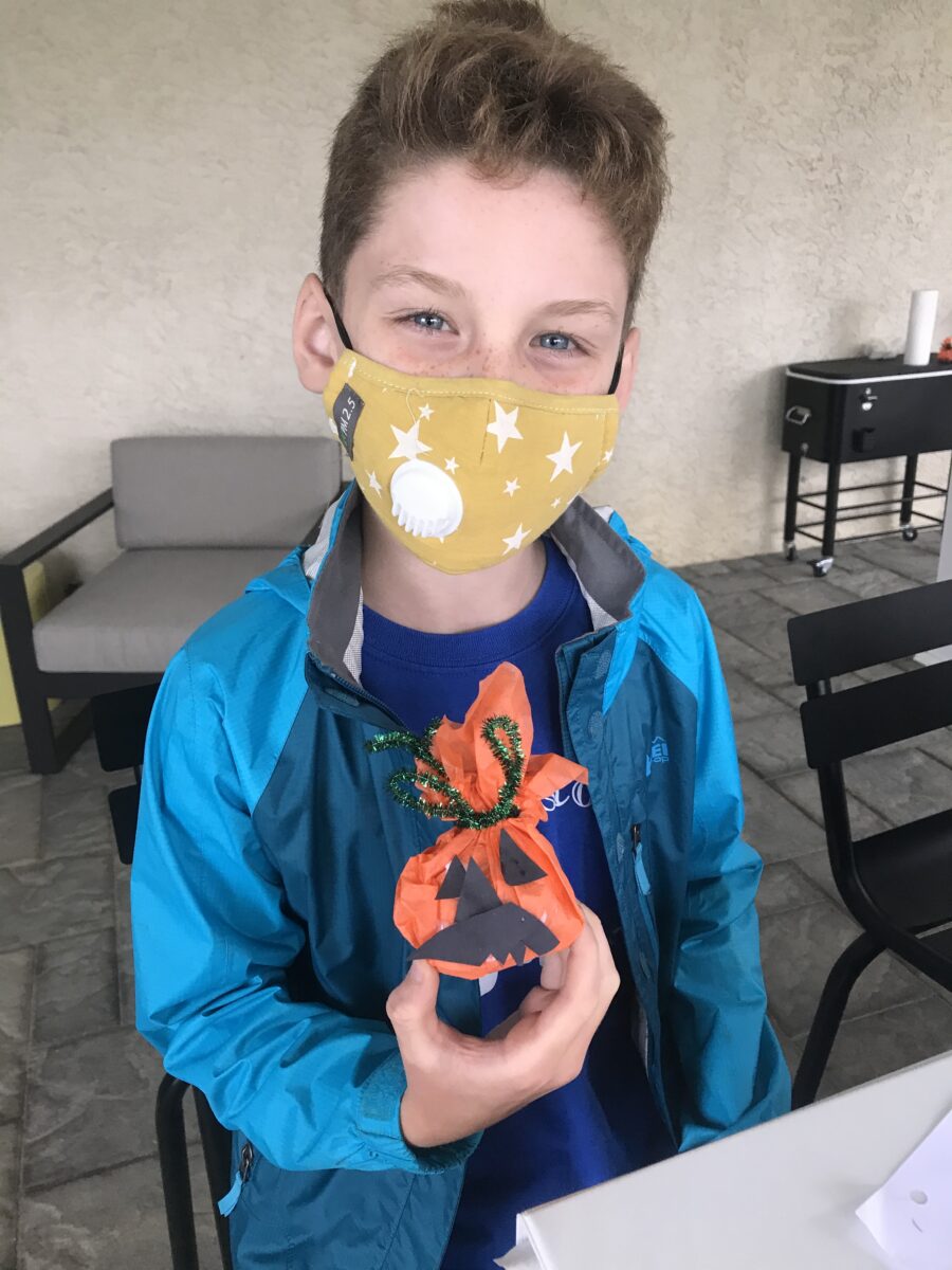 A boy wearing a mask holding an object.