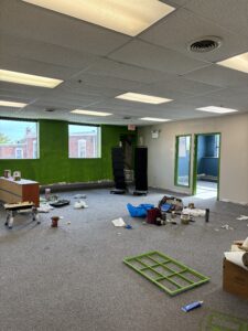 Here's a short alt tag for the image: `Office under renovation with green accent wall`